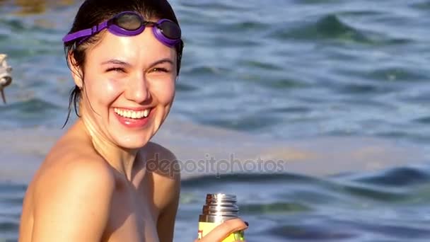Счастливая молодая женщина смеется с термосом в руке на берегу Красного моря — стоковое видео