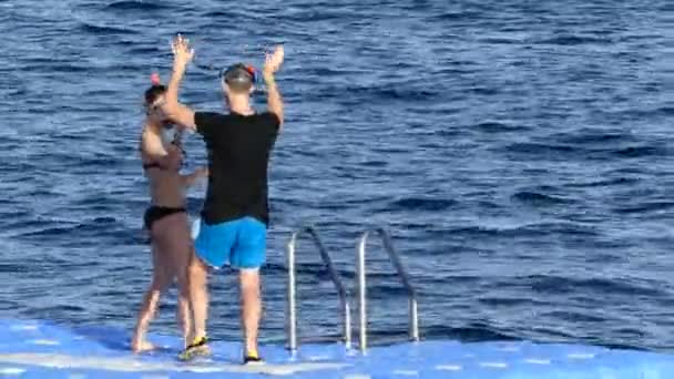Jonge Man en vrouw in Swimwuits met Snorkels staan op een ponton in Egypte. — Stockvideo