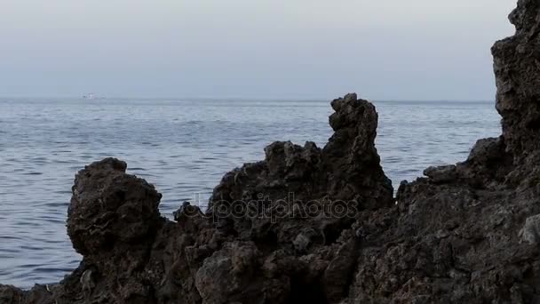 Βραχώδη Seacoast με αινιγματικά σχήμα μεγάλο μαύρο λίθο το βράδυ — Αρχείο Βίντεο