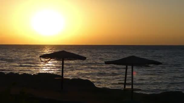 Stro Sunsheds op een strand in Egypte bij een prachtige zonsondergang in het voorjaar — Stockvideo