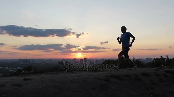 Mladý muž, běhy a skoky na nebetyčná oblasti ve východní Evropě při západu slunce v Slo-Mo — Stock video