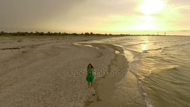 Letecký snímek šťastné děvče něco hází na pobřeží ostrova Dzharylhach v Slo-Mo — Stock video