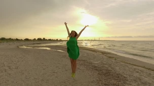 Життєрадісна дівчина, стрибки на піщане узбережжя острова Dzharylhach в уповільненому Русі — стокове відео