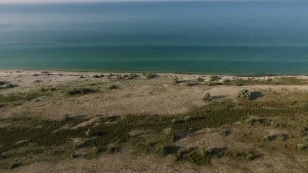 Luftaufnahme der türkisfarbenen Wellen des Schwarzen Meeres unweit der Küste der Insel Dscharylhach an einem sonnigen Tag — Stockvideo