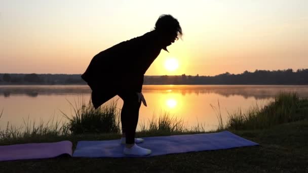 Two Women Bend Their Backs Down and up on a Lake Coast in Autumn — Stock Video