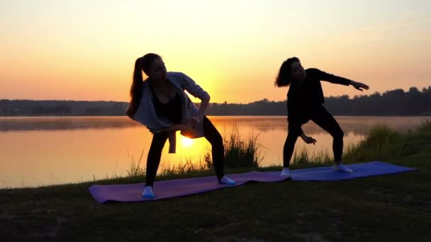 Δύο γυναίκες στροφή δεξιά και αριστερά, ενώ αυξάνοντας τα χέρια τους στο ηλιοβασίλεμα σε Slo-Mo — Αρχείο Βίντεο