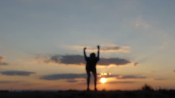 Fiatal férfi ugrik egy hegyvidéki területen nagy naplementekor — Stock videók