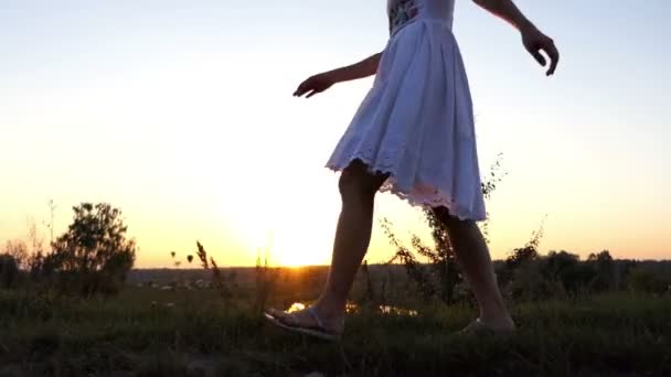 Las piernas de la mujer hermosa caminan en perfil a lo largo de una orilla del lago en una puesta de sol espléndida en Slo-Mo — Vídeos de Stock