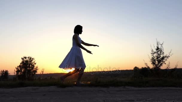 Νεαρή γυναίκα άλματα στον αέρα, αγγίζει τα τακούνια, έναν ωραίο ηλιοβασίλεμα στο Slo-Mo — Αρχείο Βίντεο
