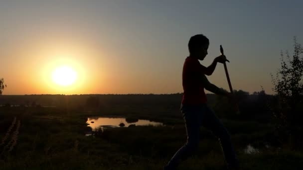 Küçük çocuk Kung-Fu darbeler bir göl kıyısında Güz Slo-mo gün batımında grev — Stok video