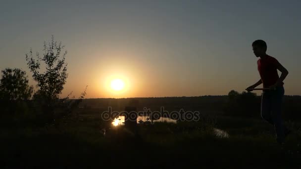 Маленький хлопчик стрибає і поїздів кунг фу удари на березі озера в Sunset восени в Slo-Mo — стокове відео