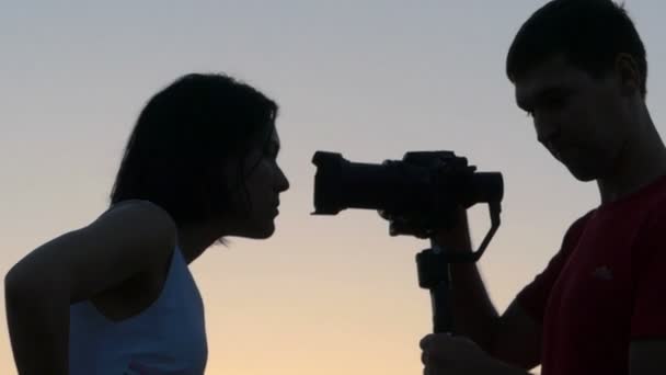 Jeune femme regarde un objectif de caméra et rit heureusement au coucher du soleil à Slo-Mo — Video