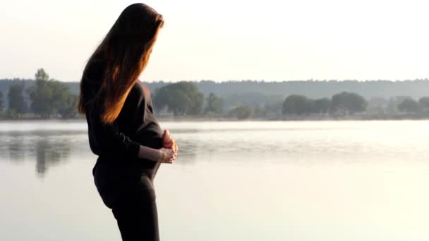 Una mujer embarazada rolics con zapatillas para su bebé al atardecer en otoño en Slo-Mo — Vídeo de stock