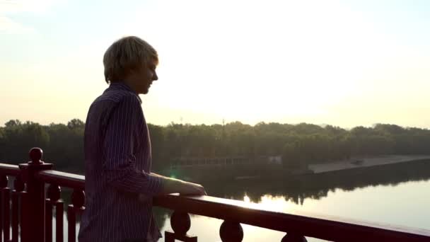 Un homme souriant bénéficie d'une vue pittoresque sur la rivière Dnipro depuis le pont de Slo-Mo — Video