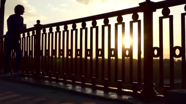 Happy Man se levanta com uma xícara de papel de café e se diverte como ao pôr do sol — Vídeo de Stock