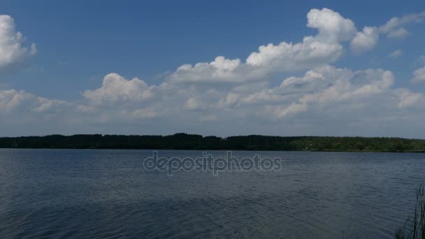 Krajina s modrým nebem nad jezerem. — Stock video