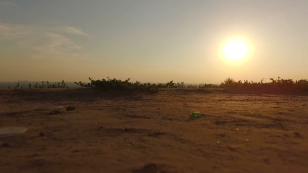 De start van de drone vliegen omhoog uit de grond bij zonsondergang. — Stockvideo