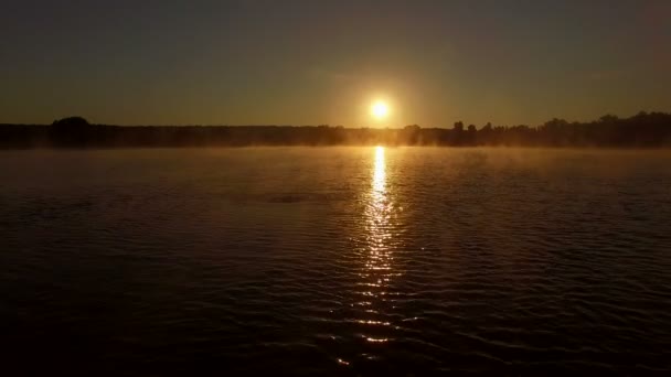 Jovem brinca com água ao pôr-do-sol no lago . — Vídeo de Stock