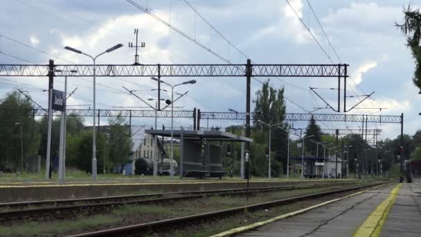 Plataforma de una estación ferroviaria con construcciones metálicas y semáforos — Vídeo de stock