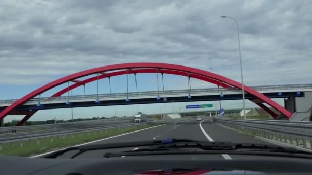 Um carro se move em direção a uma ponte hemisférica em uma rodovia moderna — Vídeo de Stock