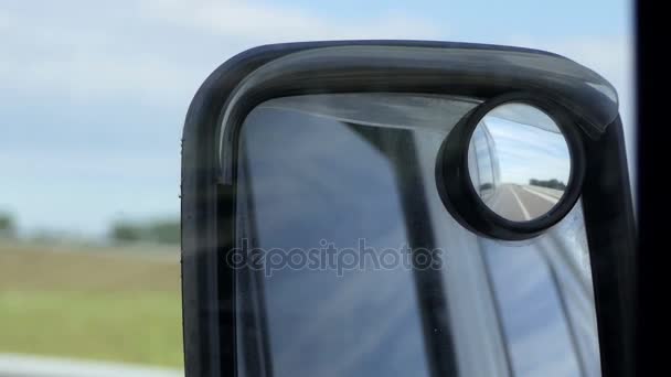 Крыло зеркала из салона движущегося автомобиля имеет различные отражения в летнее время — стоковое видео