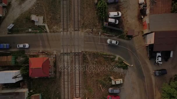 Aerial shot of a moving train crossing the asphalt road with cars — Stock Video