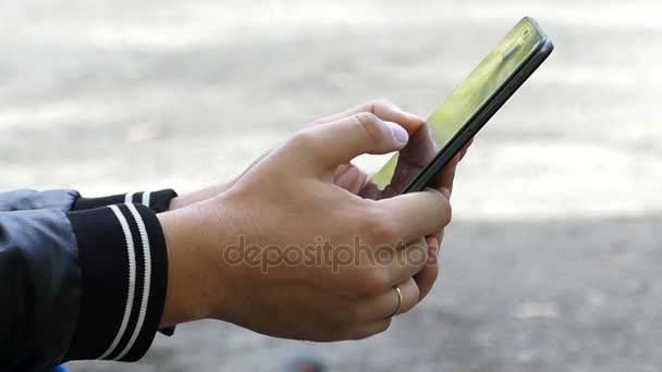 Mladý mans ruce dotyková obrazovka smartphone venku v slo-mo — Stock video