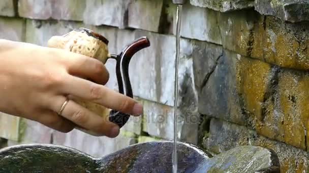 Um fluxo de água saudável e nutritiva flui em uma panela de barro no outono — Vídeo de Stock