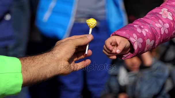 Un clovn dă un chupa chups bomboane unui copil în mișcare lentă — Videoclip de stoc