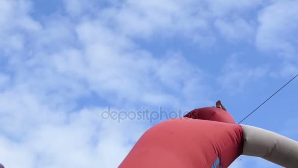 Une drôle de silhouette en caoutchouc rouge plein d'air oscille par temps venteux — Video