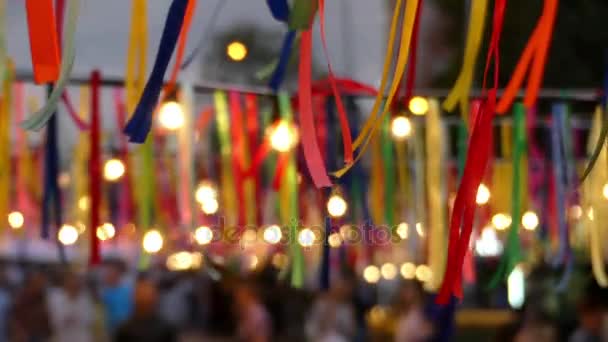 Viele bunte Streifen mit Lampen, die im Sommer auf der Straße hängen — Stockvideo