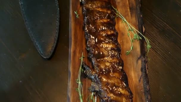 テーブルの上の長い木製の皿にスモークの肋骨 — ストック動画
