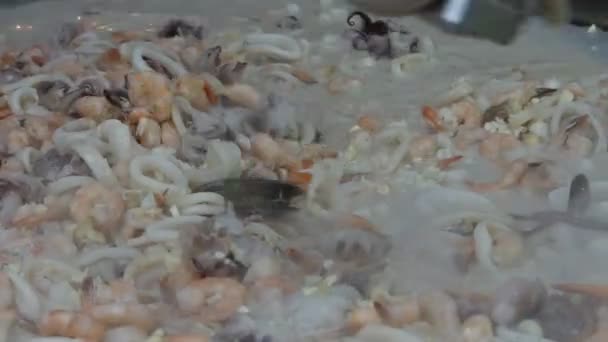 Krevety, mussles a cibule jsou vařené a smíšené na kovový zásobník — Stock video