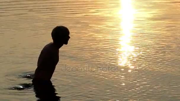 Young Man Raises River Water in Palms And Throws it up at Sunset — Stock Video