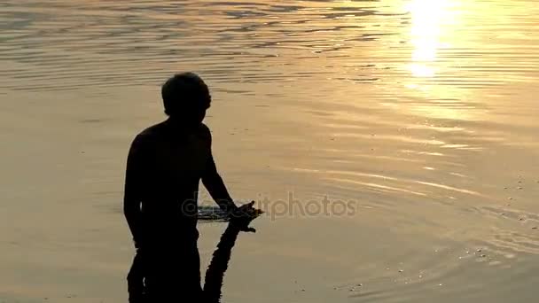 Арти-человек передвигает речную воду со своей ладонью на закате солнца — стоковое видео