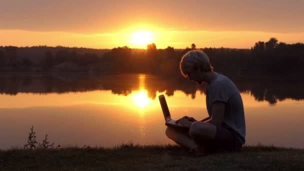 Studentin arbeitet bei Sonnenuntergang mit Laptop. — Stockvideo