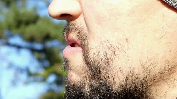 Un primer plano de un joven barbudo que muestra los dientes con irritación — Vídeo de stock