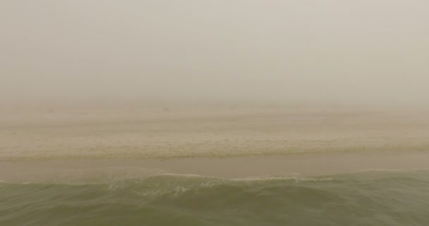 Luchtfoto van een vrouw staande op een Yoga Mat en het draaien van haar handen op een strand — Stockvideo