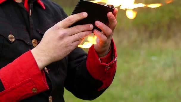 Kouzelník se otevře peněženku a nastaví ji na ohni. Rány a získá obrovský požár v Slo-Mo — Stock video