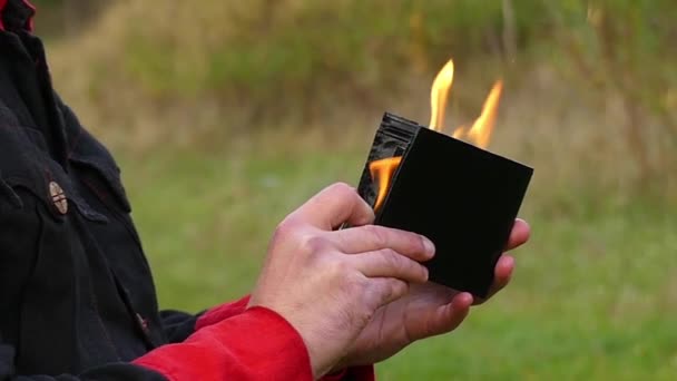男子打开钱包, 并设置在火上。他在斯洛伐克中吹火 — 图库视频影像
