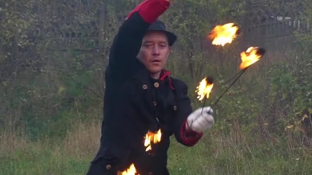 Fire Man tord deux ventilateurs lumineux autour de lui à l'extérieur à Slo-Mo en automne — Video