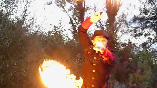 Jongleur dreht in Zeitlupe zwei Feuerbälle über seinem Kopf in einem Wald — Stockvideo
