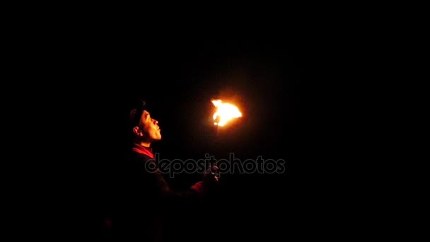 Žonglér údery na zapálenou pochodeň a způsobuje obrovské plamenem hluboko v noci v Slo-Mo — Stock video