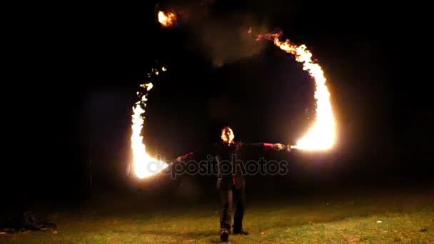 Žonglér rány na jeho osvětlené pochodněmi a způsobuje obrovské plamen v noci v Slo-Mo — Stock video