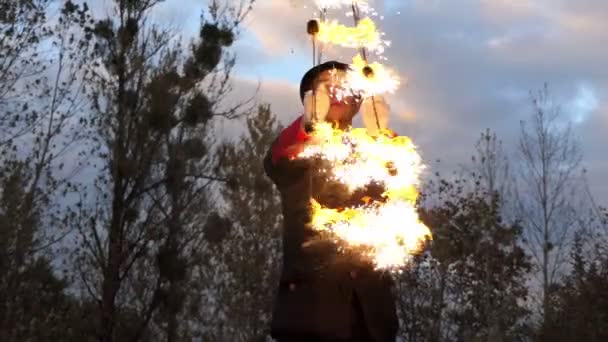 Fire Man retuerce dos ventiladores de luz alrededor de sí mismo al aire libre en Slo-Mo en otoño . — Vídeo de stock