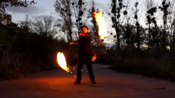 Malabarista gira dos bolas de fuego en los cables largos por la noche. Parece magia en Slo-Mo — Vídeo de stock