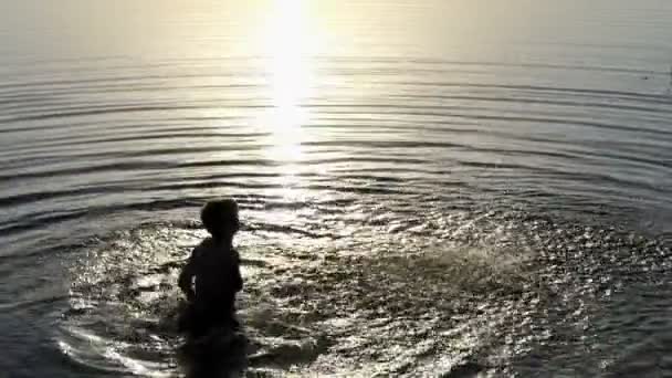 Μια χαλαρή γυναίκα πηγαίνει έξω από τα νερά της λίμνης στο ηλιοβασίλεμα σε slo-mo — Αρχείο Βίντεο