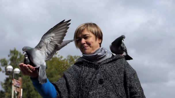 Mooie vrouw houdt duiven op haar hand in slo-mo — Stockvideo