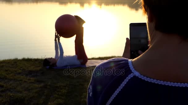 Joven mujer entrena con un fitball, el segundo le dispara en slo-mo — Vídeo de stock