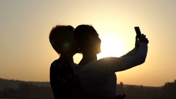 Onların smartphone slo-mo bir göl kıyısında iki kadın bakmak — Stok video